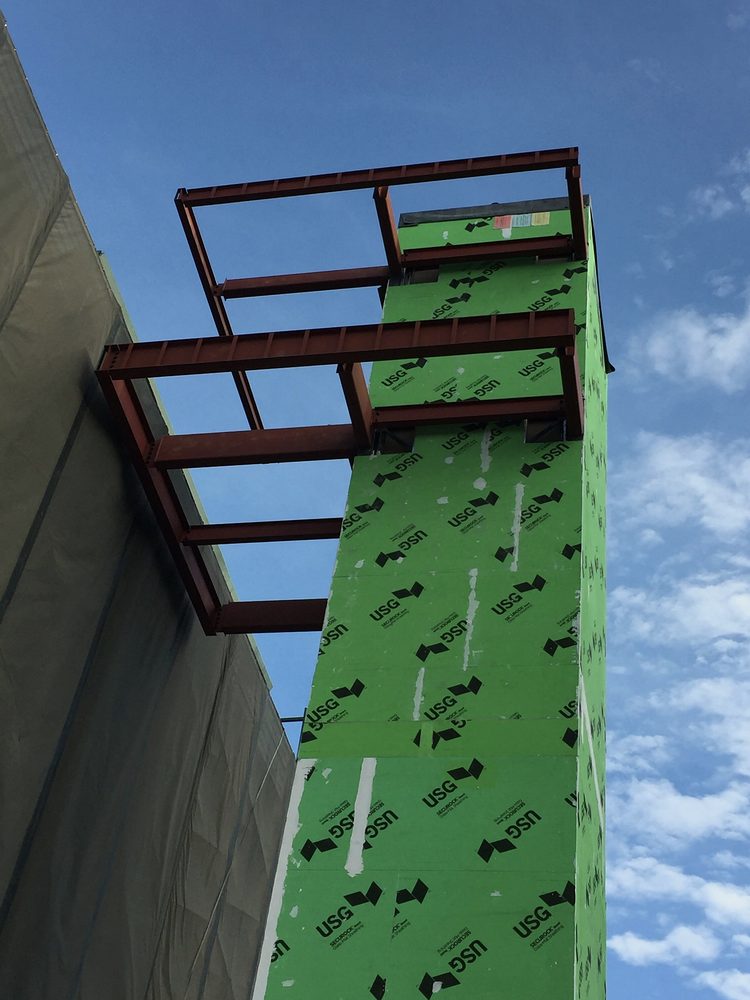 Red primed steel framing on an elevator tower